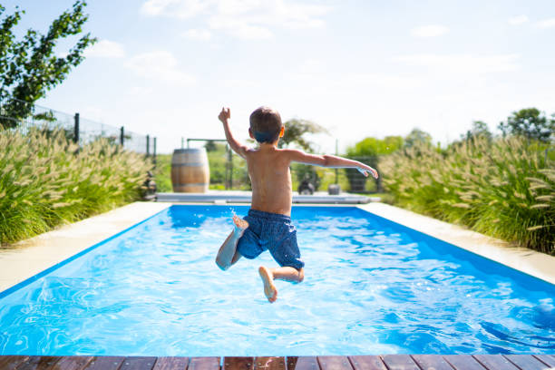 istockphoto-1161183492-612x612 rear view of 4 year old boy jumping into private pool on sunny vacation day - boy is unrecognizable so can be used anonymous summer fun series